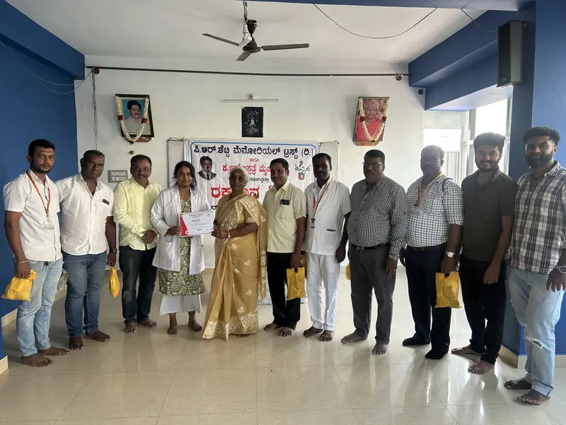 Doctors and volunteers at a blood donation camp, standing in front of the camp banner